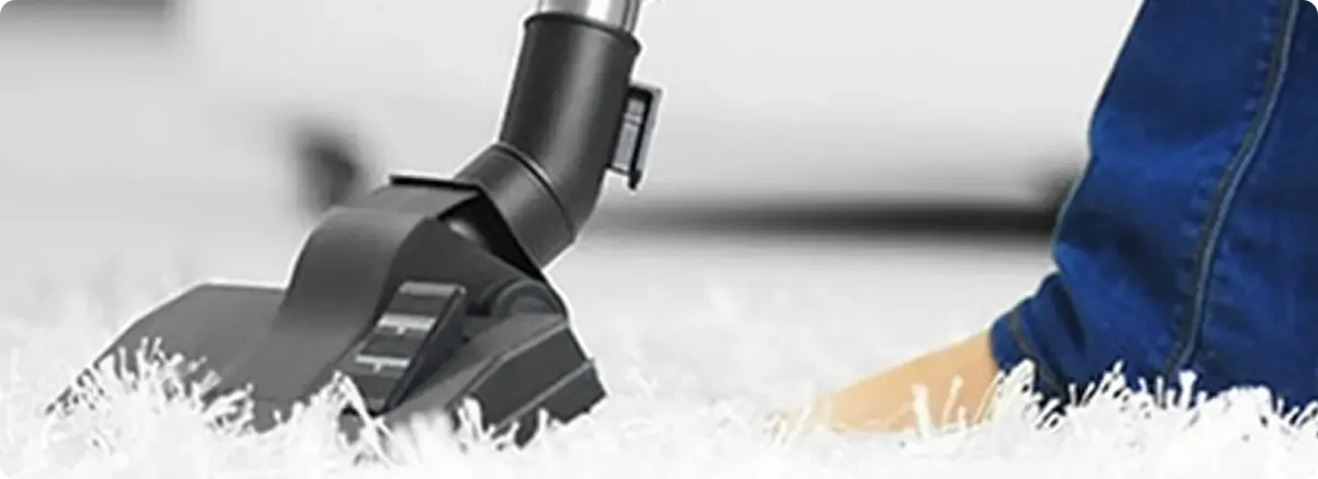 Close-up of a professional vacuuming a white carpet in Waunakee.
